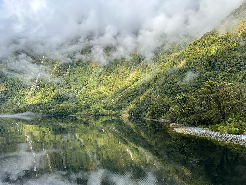 Weerspiegeling en watervallen in Doubtful Sound